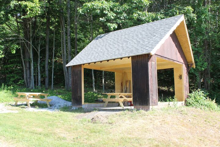 Open-sided pavilion beside the wooded course